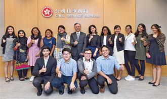 Mr Law (back row, sixth left) met the non-ethnic Chinese university students and local secondary students, who participated in the government internship programme and the "Be a Government Official for a Day" programme.