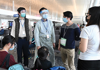 Mr Nip (second left), as the then SCMA, sent his regards to a family from Enshi who was waiting to board the chartered flight to Hong Kong at the Wuhan Tianhe International Airport.