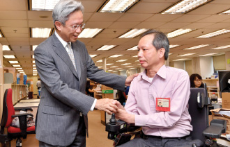 Mr Law (left) chatted with a colleague to know more about the assistance provided by the Inland Revenue Department to help the disabled integrate into the workplace during a visit.