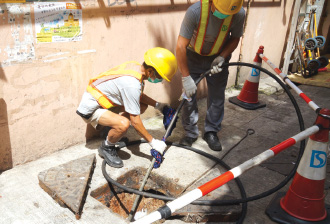 渠務署員工於颱風後協助清理雨水渠。