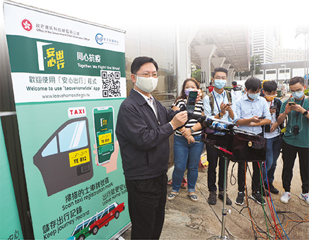 Mr Sit (first left), continuously promoted the "LeaveHomeSafe" mobile app to different sectors in the society to fight the epidemic together.