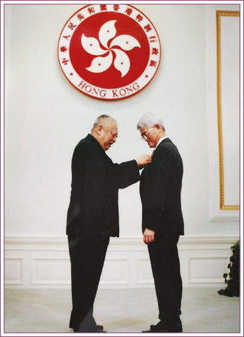 袁先生(右)获颁授荣誉勋章，以表扬他对推行电子假期系统所作出的卓越贡献和杰出表现。