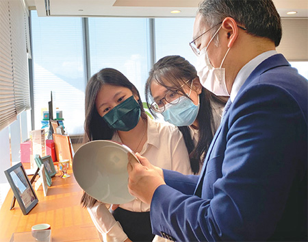 Mr Hui appreciated an antique bowl with visiting students to his office in August last year.