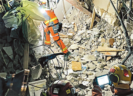 救援隊員以超寬頻雷達技術及三百六十度搜索鏡頭探測瓦礫下有否生命跡象，有關儀器對呼吸及微細動作最遠探測距離分別為十米及十二米。(相片由消防處提供)