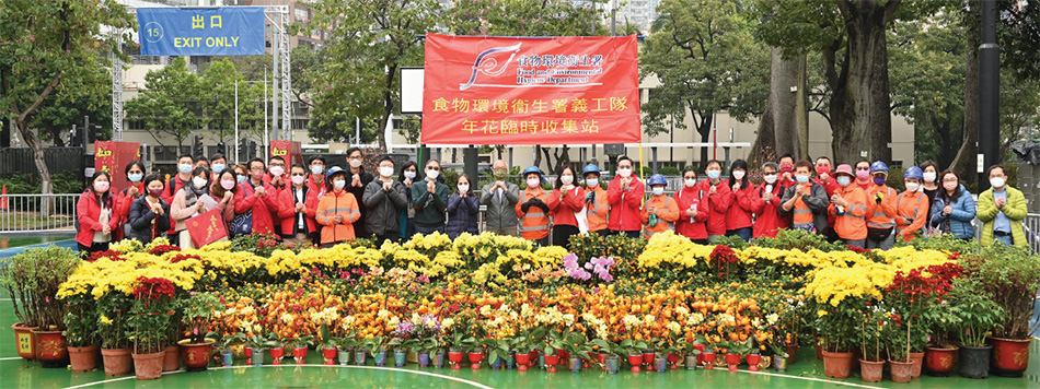 Mr Tse Chin-wan, Secretary for Environment and Ecology, Miss Diane Wong, Under Secretary for Environment and Ecology, and Ms Irene Young, Director of Food and Environmental Hygiene, took a group photo with FEHD volunteers who participated in the New Year Flower Giveaway activity.