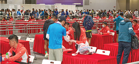The Civil Service Volunteer Teams were responsible for verifying the identities of the runners at the registration counters, carefully wearing the identification bracelets for runners and controlling crowds at the Asiaworld-Expo on the event day of the "Hong Kong-Zhuhai-Macao Bridge (Hong Kong Section) Half Marathon 2023”.