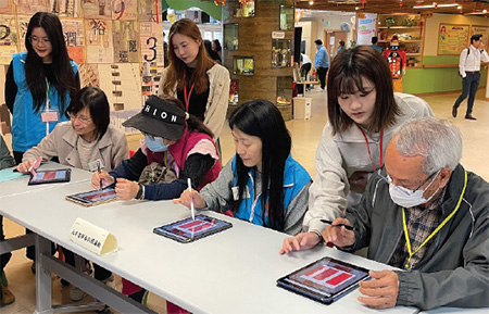 The Assistant Government Chief Information Officer, Ms Cari Wu Wa (first row, second right) and the elderly used tablets to create their own couplets.