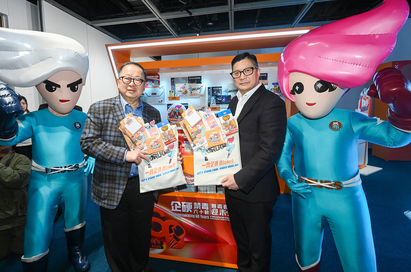 Mr Tang (right) and the Chairman of ACAN, Dr Donald Li Kwok-tung (left) received anti-drug souvenirs at ACAN's 60th anniversary commemorative events. 
