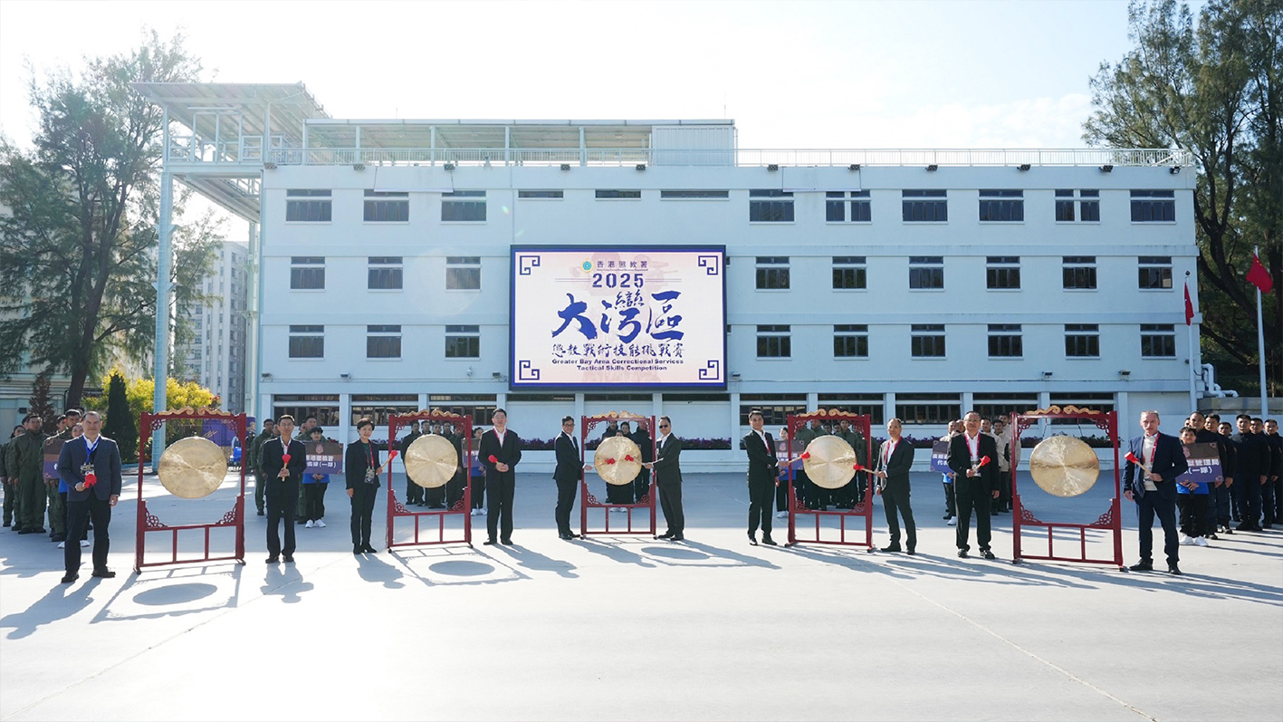 二零二五年一月十三日，懲教署主辦的首屆大灣區懲教戰術技能挑戰賽揭開序幕，有超過一百名來自內地、澳門及香港的懲教人員參與。鄧局長(左五)與主禮嘉賓一同主持開幕儀式。 
