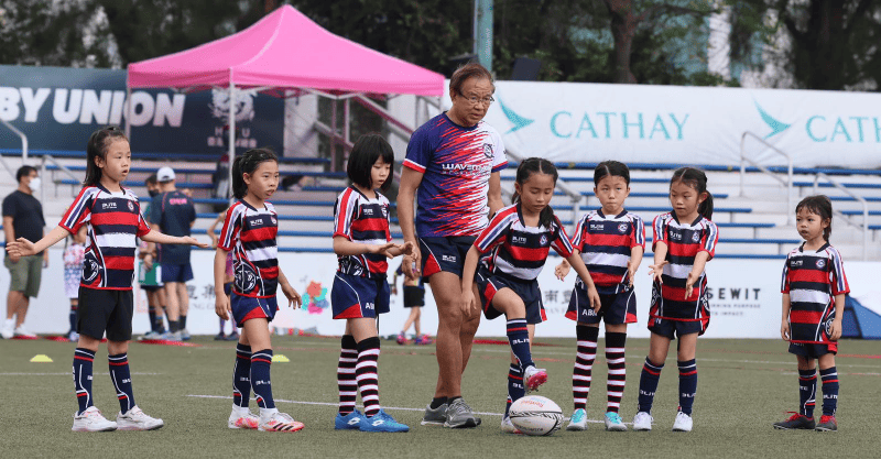 Mr Wong (fourth left) is passionate about teaching children how to play “touch rugby”. 
