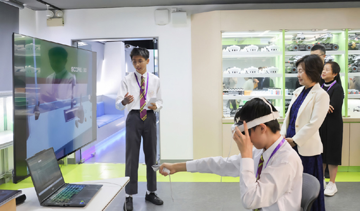 蔡局長（右二）到訪迦密柏雨中學，了解學校推行STEAM（科學、科技、工程、藝術和數學）教育的情況。