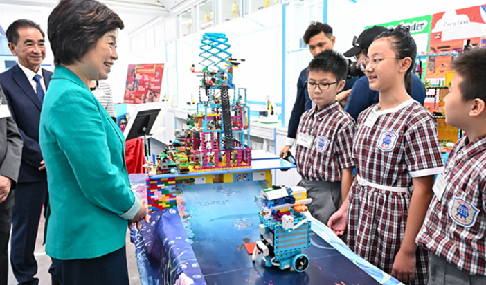 Dr Choi (second left) visited Tai Po Old Market Public School and toured the innovation and technology (I&T) laboratory of the school while listening to students’ presentations of I&T works.